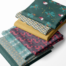 Geometric Christmas fabric. Robin, holly, stars and geometrics in jewel tones of bright greens, gold and pink